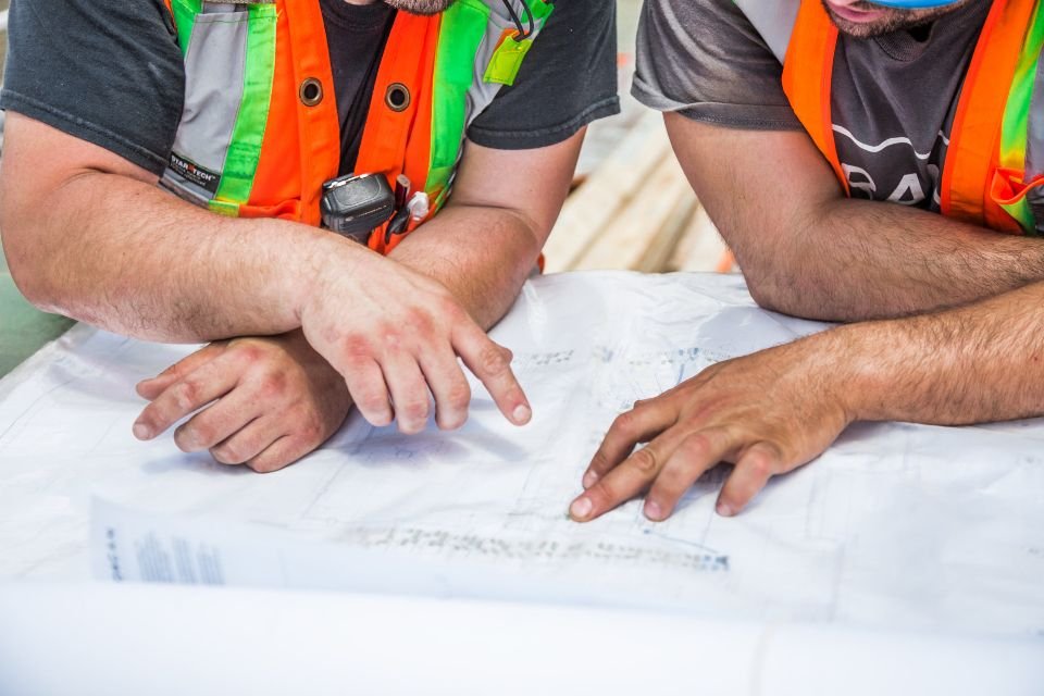 Hands reviewing documents together on a table, reflecting the written policy work behind a compliant testing program