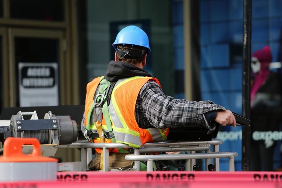 A worker in a hard hat and high visibility gear at plant machinery, the mixed non-DOT workforce a company policy has to cover