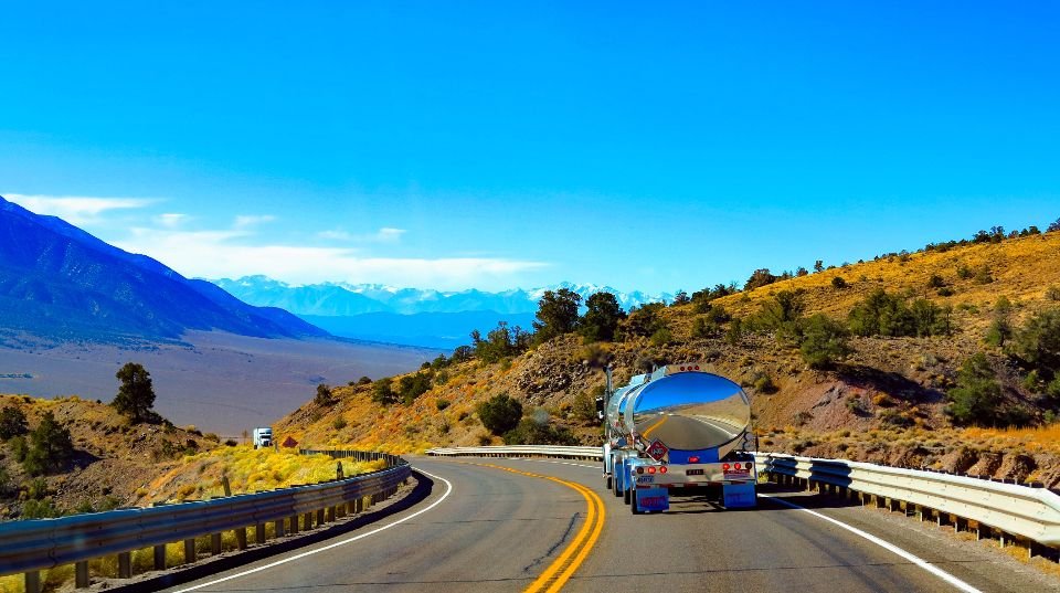 A truck working a highway through the hills, the kind of route our collectors cover across the state every week