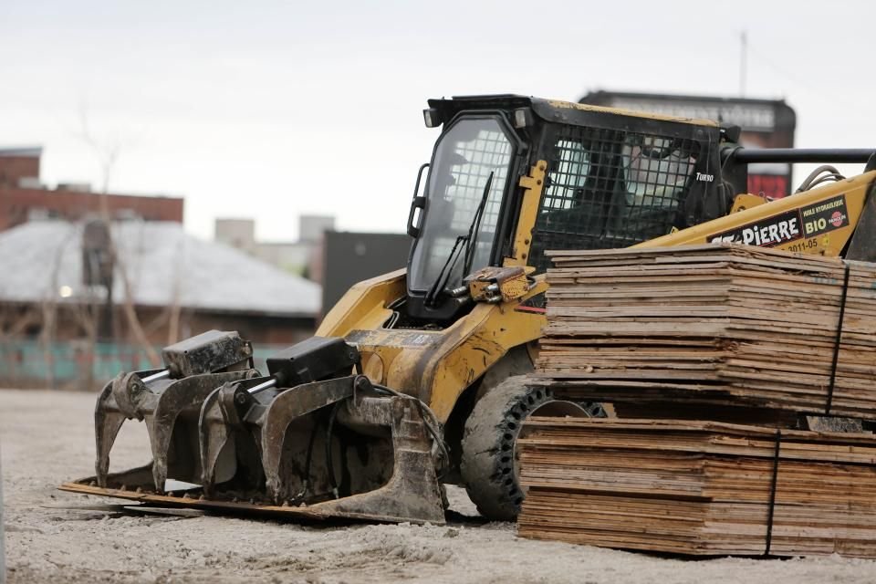 A loader working on a construction site, where post-accident collections often need to happen outside clinic hours